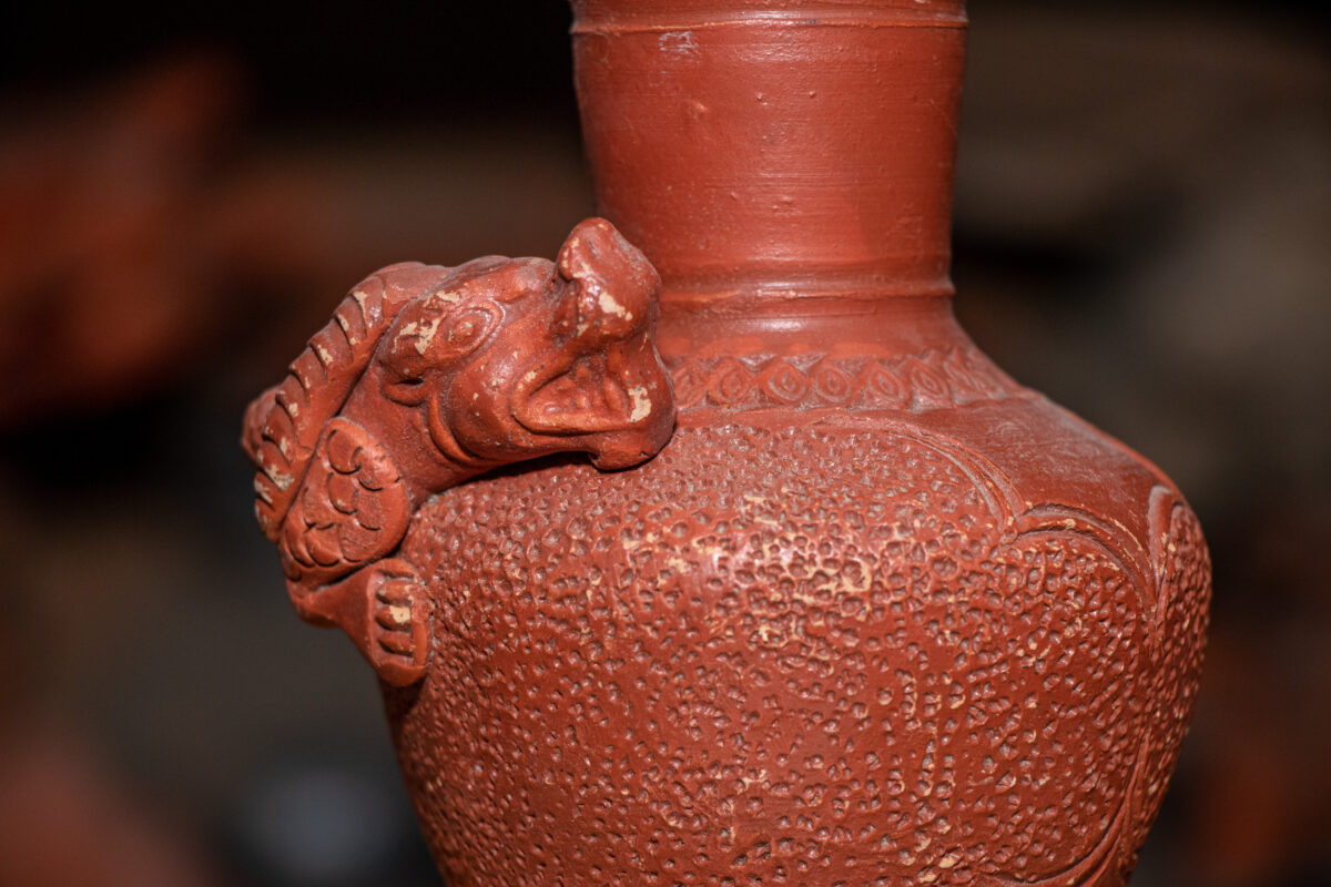Mythical creature carved clay vase